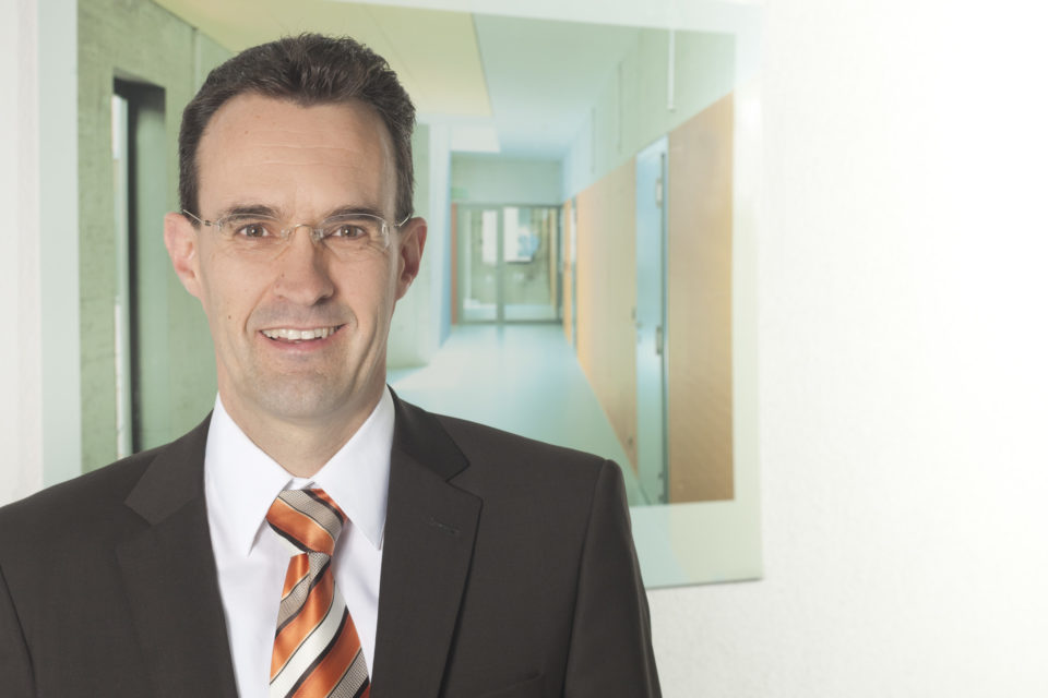 Auf dem Foto ist eine Person im Anzug zu sehen.
