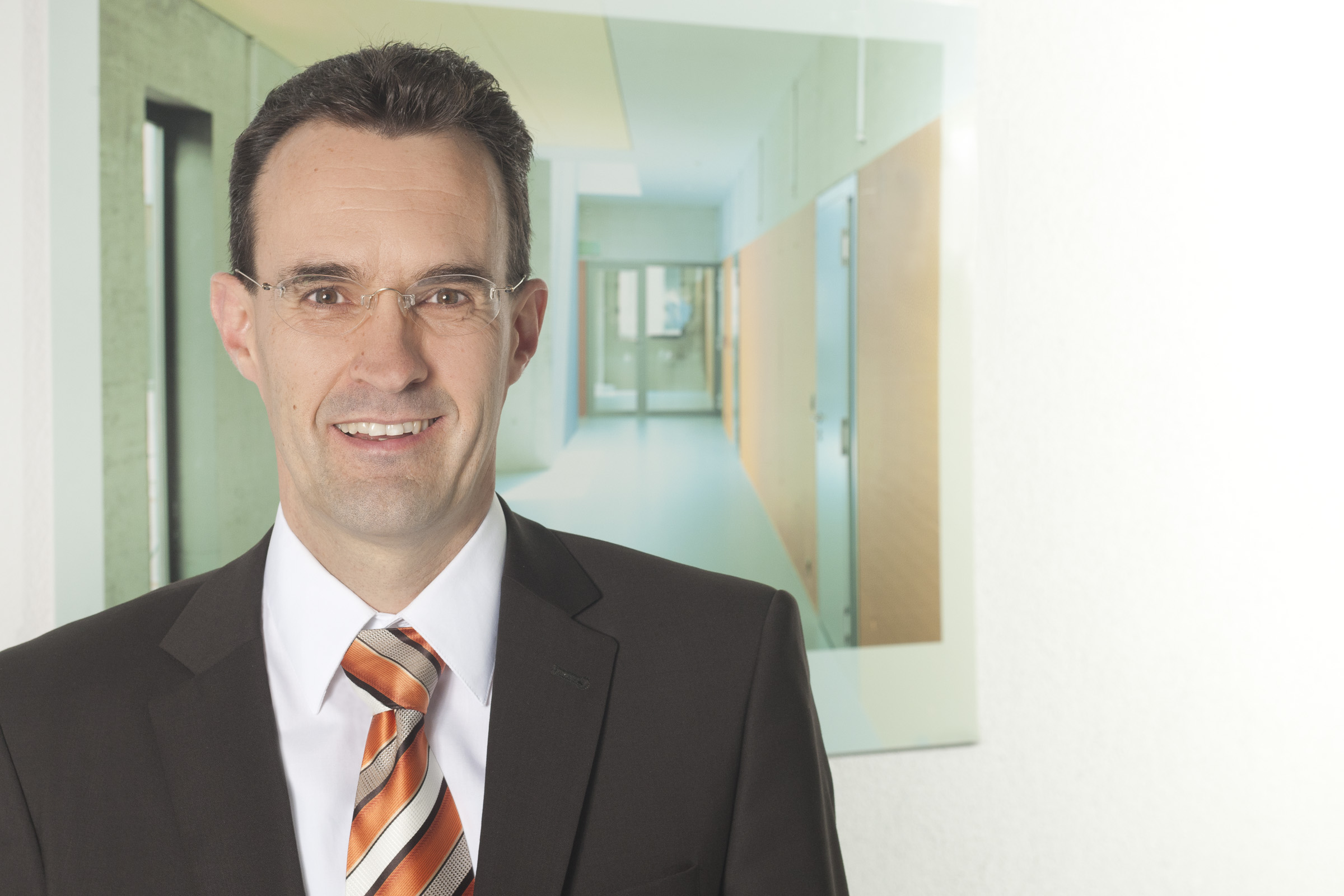 Auf dem Foto ist eine Person im Anzug zu sehen.